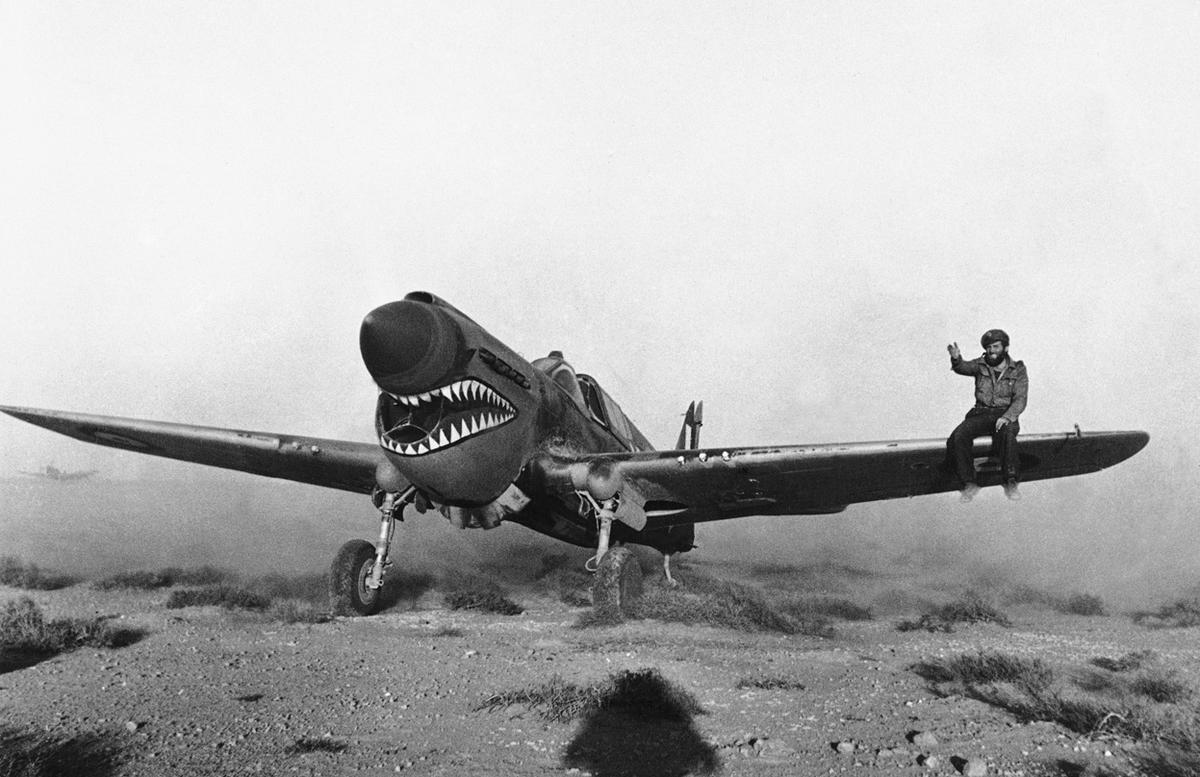 Un piloto británico aterriza un avión de combate de fabricación estadounidense Kittyhawk del Escuadrón Sharknose en una tormenta de arena en Libia, el 2 de abril de 1942. Un mecánico en el ala ayuda a guiar al piloto a través de la tormenta